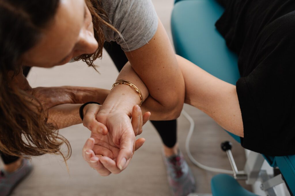 Stretch Therapist gently holding a clients arm and hand