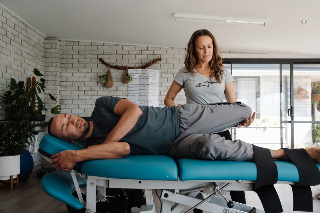 Stretch Therapist moving a client who is laying down